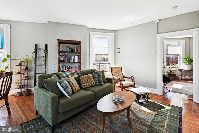 living area with baseboards and wood finished floors