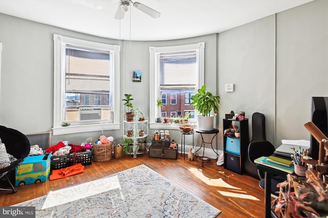 playroom with a ceiling fan, cooling unit, and wood finished floors