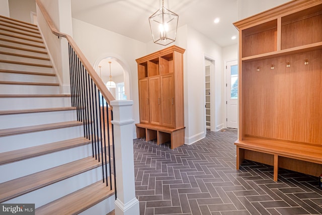 mudroom featuring recessed lighting, a notable chandelier, arched walkways, and baseboards