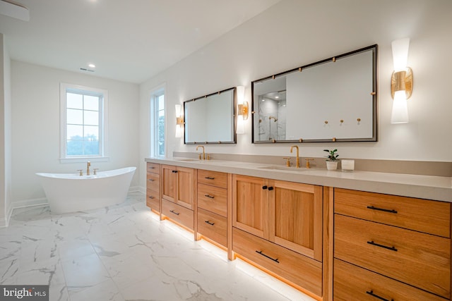 bathroom featuring double vanity, marble finish floor, a freestanding tub, and a sink