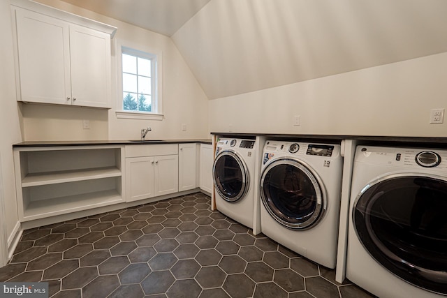 laundry area with cabinet space, independent washer and dryer, dark tile patterned floors, and a sink