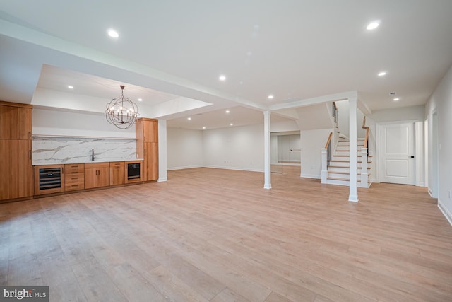 unfurnished living room featuring light wood-type flooring, wine cooler, stairway, and recessed lighting