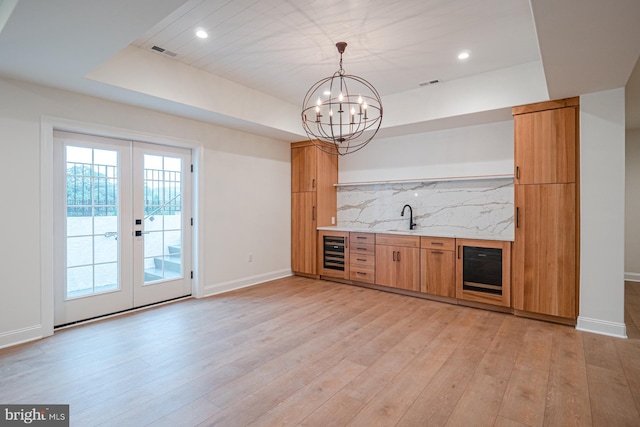 bar featuring beverage cooler, light wood finished floors, backsplash, and visible vents