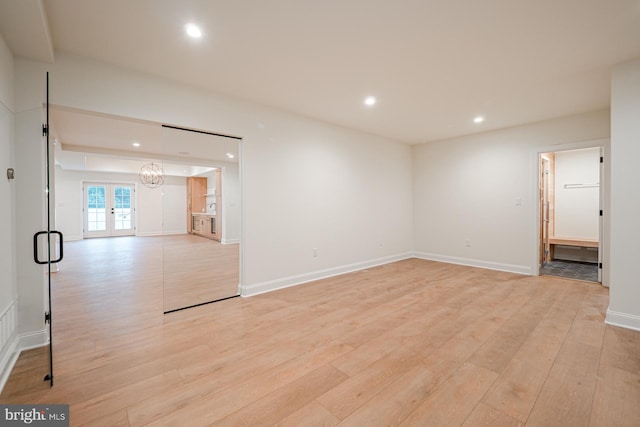 empty room featuring light wood-style flooring, baseboards, french doors, and recessed lighting