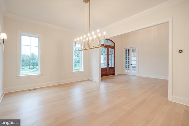 interior space with light wood-style floors, baseboards, crown molding, and french doors