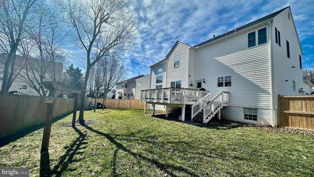 back of house featuring a yard, a wooden deck, stairs, and a fenced backyard