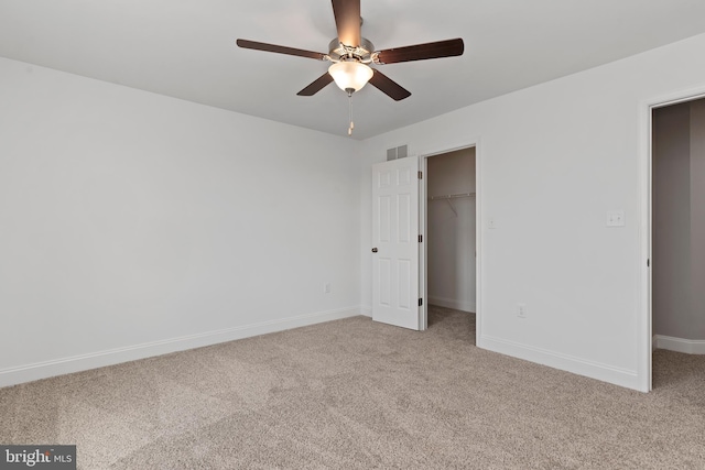 unfurnished bedroom with light carpet, baseboards, visible vents, a spacious closet, and a closet