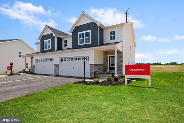 view of front facade with aphalt driveway, an attached garage, stone siding, a front lawn, and board and batten siding