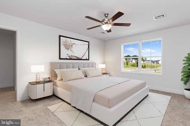 bedroom featuring ceiling fan, light colored carpet, visible vents, and baseboards