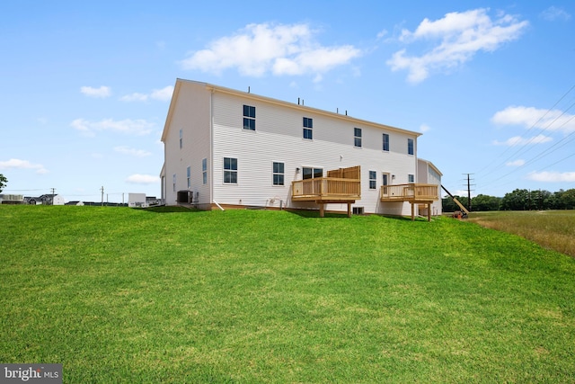 back of house with a deck, central AC, and a lawn