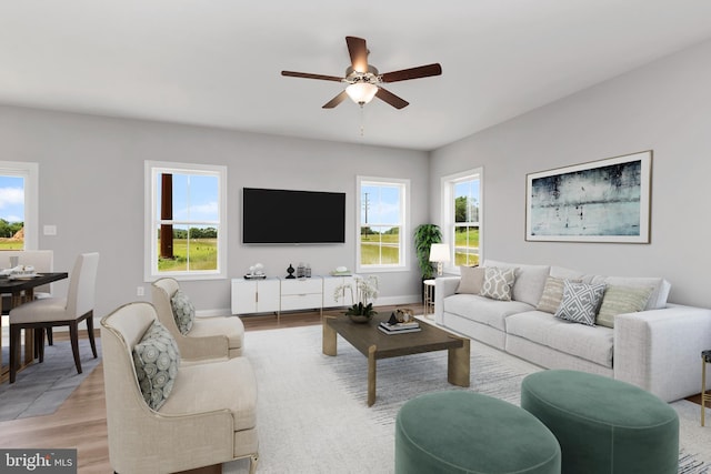 living area featuring baseboards, a healthy amount of sunlight, a ceiling fan, and light wood-style floors