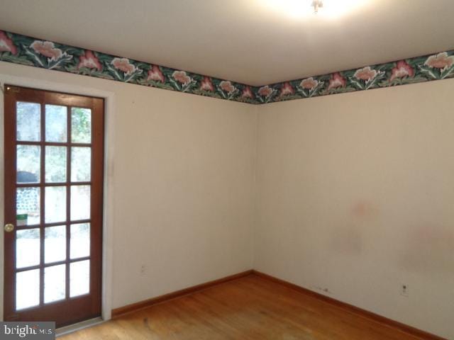 spare room with light wood-style flooring and baseboards