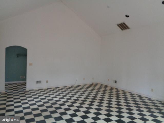 empty room with arched walkways, vaulted ceiling, and visible vents