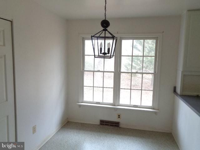 unfurnished dining area featuring visible vents and an inviting chandelier