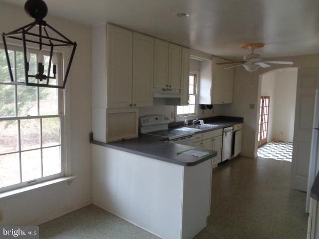 kitchen featuring ceiling fan with notable chandelier, a peninsula, electric range, stainless steel dishwasher, and dark countertops