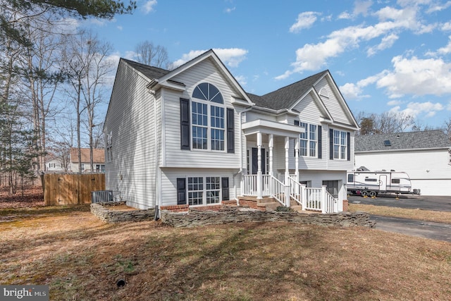 split foyer home featuring a garage, driveway, and fence