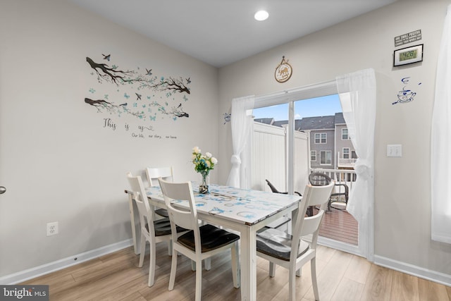 dining area with light wood-type flooring and baseboards