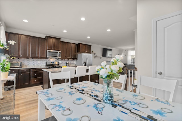 dining area featuring light wood-style floors, a toaster, and recessed lighting