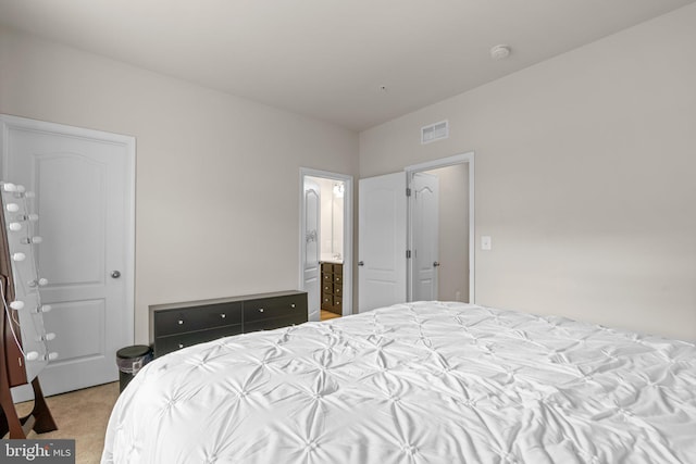 bedroom with carpet, connected bathroom, and visible vents