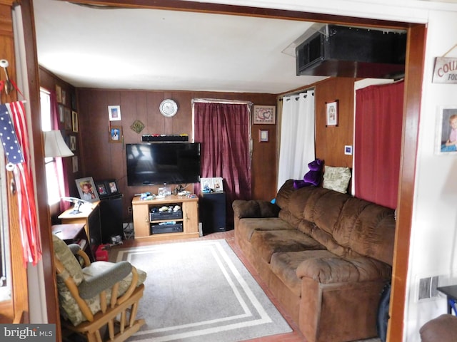 living area with visible vents and wooden walls