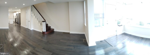 interior space featuring a wealth of natural light, stairs, and dark wood-type flooring