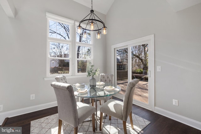 dining room featuring a healthy amount of sunlight, baseboards, a chandelier, and wood finished floors