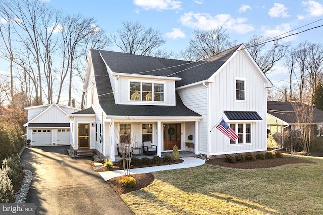 modern farmhouse with covered porch, a garage, a shingled roof, board and batten siding, and a front yard