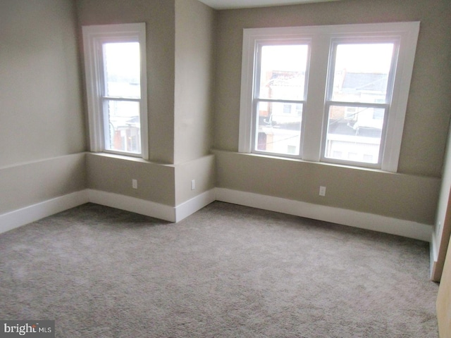 empty room with baseboards, carpet floors, and a healthy amount of sunlight