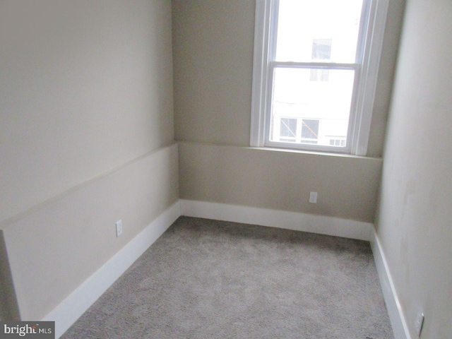 empty room with light colored carpet and baseboards