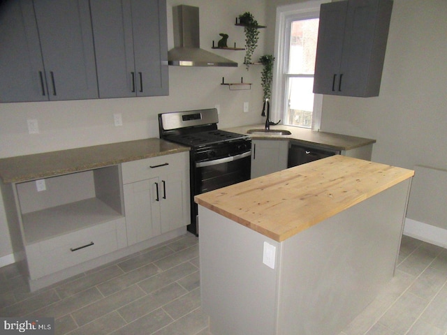 kitchen with black dishwasher, butcher block countertops, stainless steel range with gas stovetop, a sink, and exhaust hood