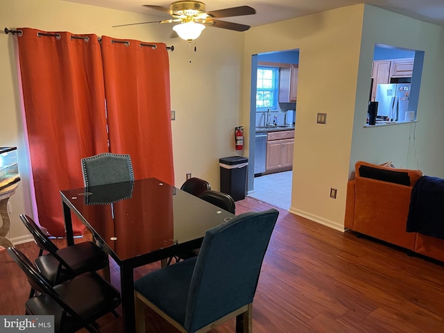 dining room featuring ceiling fan, baseboards, and wood finished floors