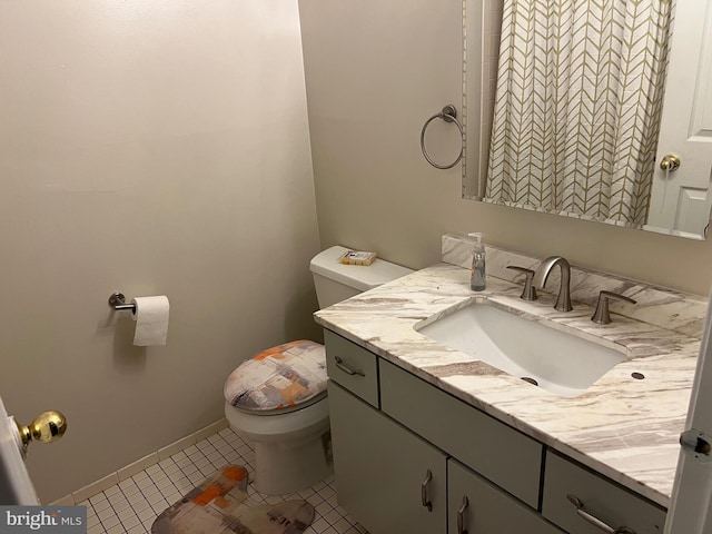 bathroom with baseboards, vanity, toilet, and tile patterned floors