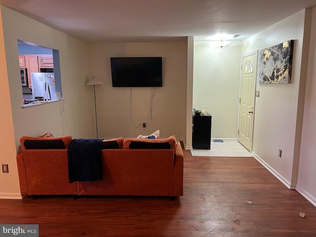 living room featuring wood finished floors, visible vents, and baseboards