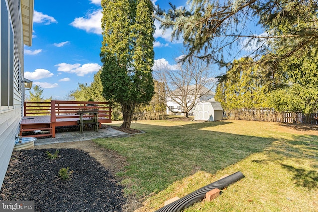 view of yard with a storage shed, fence, and an outdoor structure