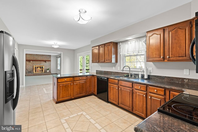 kitchen featuring a sink, black appliances, a peninsula, and light tile patterned floors