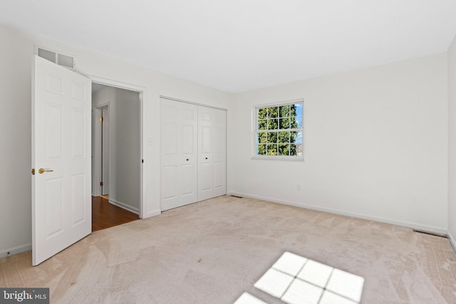 unfurnished bedroom featuring visible vents, carpet floors, and baseboards