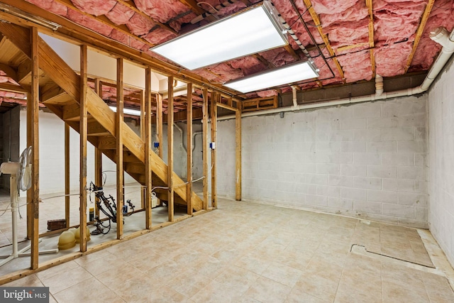 unfinished basement featuring concrete block wall