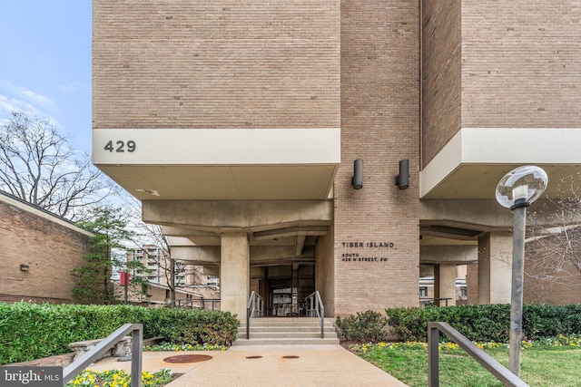 view of exterior entry featuring brick siding