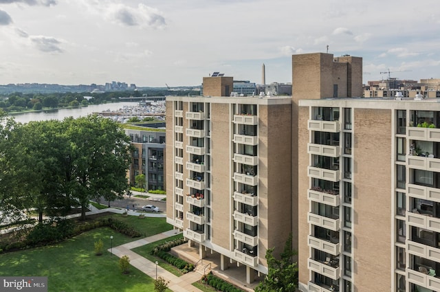 view of building exterior featuring a water view and a city view