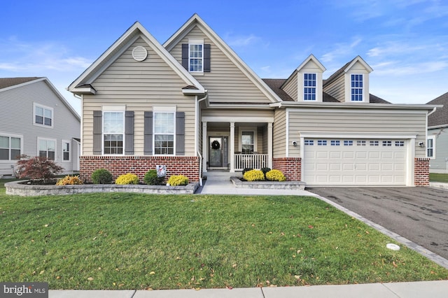 view of front of home with driveway, an attached garage, a front yard, and brick siding