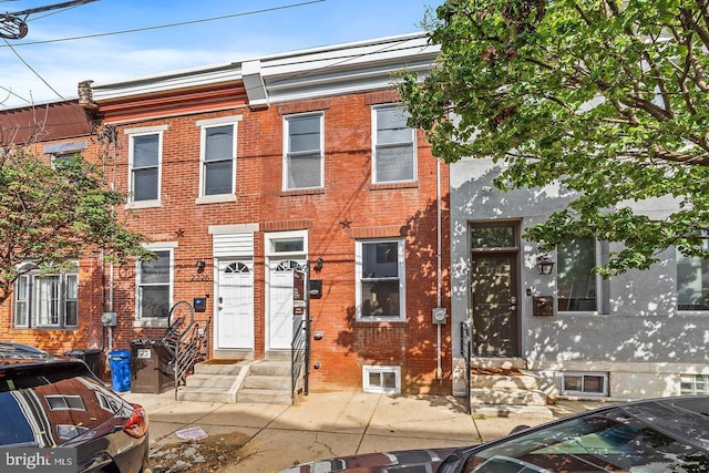 view of property with entry steps and brick siding