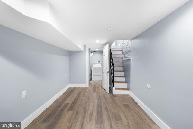 finished below grade area with stairway, washer / dryer, wood finished floors, and baseboards