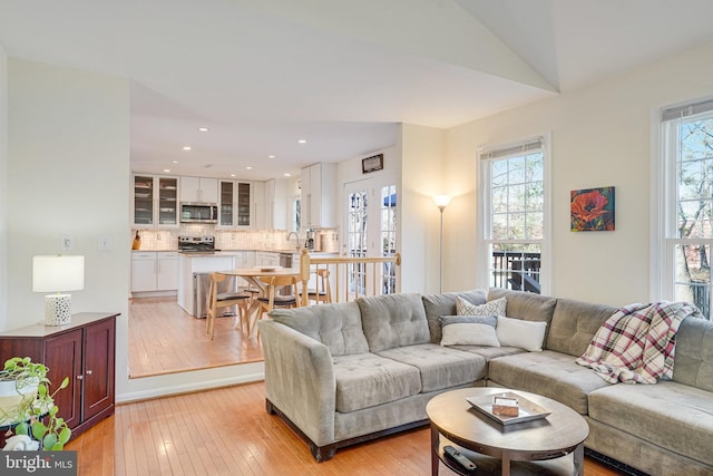 living room with light wood-type flooring and recessed lighting