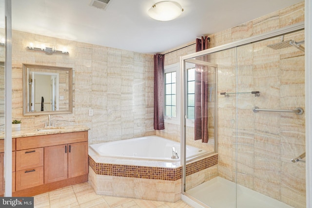 full bath with visible vents, a garden tub, vanity, a shower stall, and tile walls