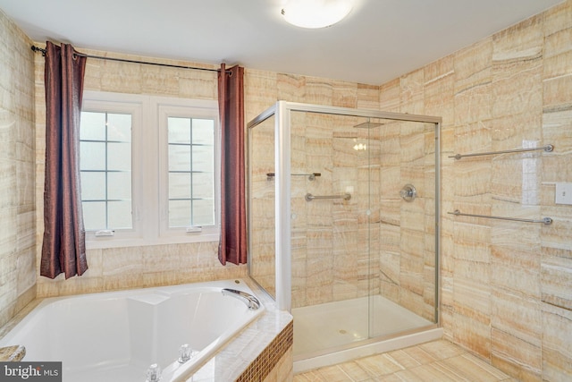 bathroom featuring a shower stall and a bath