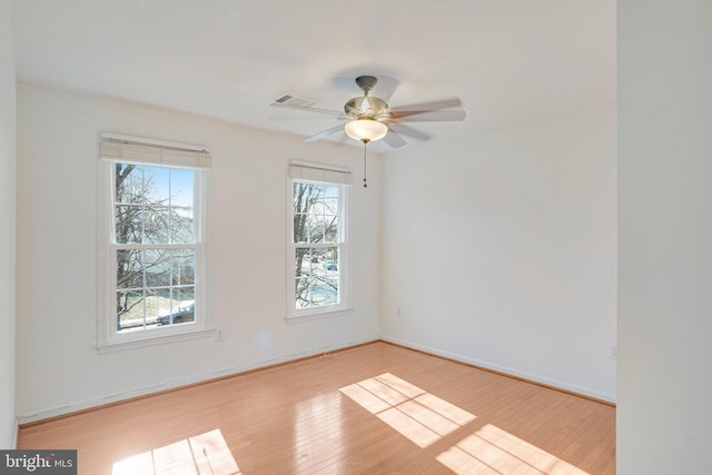 unfurnished room featuring visible vents, ceiling fan, baseboards, and wood finished floors