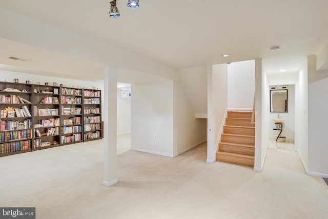 finished below grade area featuring carpet floors, baseboards, stairs, and visible vents