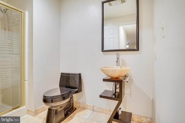 bathroom with a stall shower, visible vents, a sink, and baseboards