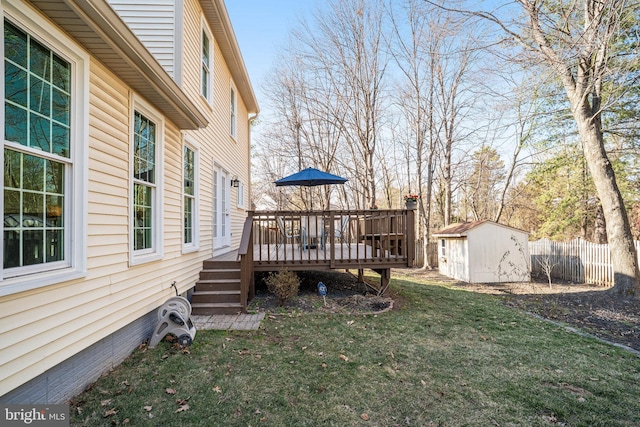 view of yard featuring an outbuilding, fence, a deck, and a storage shed