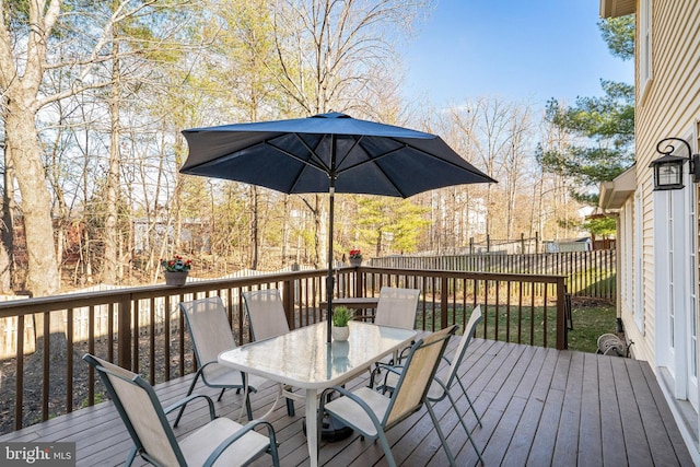 wooden deck with outdoor dining area and fence